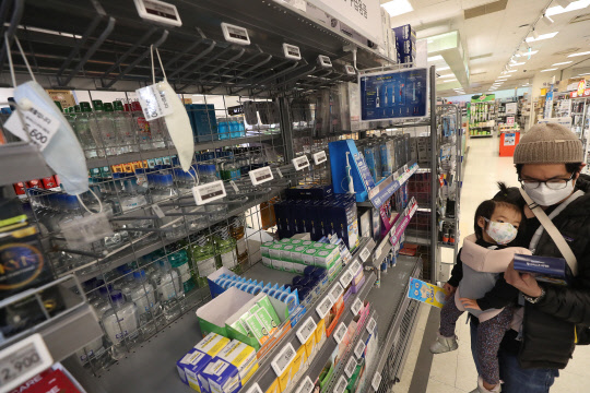 텅빈 마스크 진열대  신종 코로나바이러스 감염증인 '우한 폐렴'의 확산으로 마스크 등 위생용품 판매가 급증한 28일 서울의 한 대형마트에서 외국인 부녀가 아동용 마스크를 살펴보고 있다.  연합뉴스